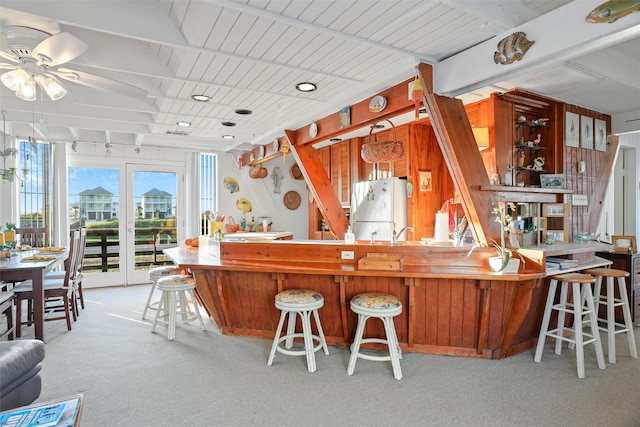 kitchen featuring kitchen peninsula, light carpet, ceiling fan, and white refrigerator