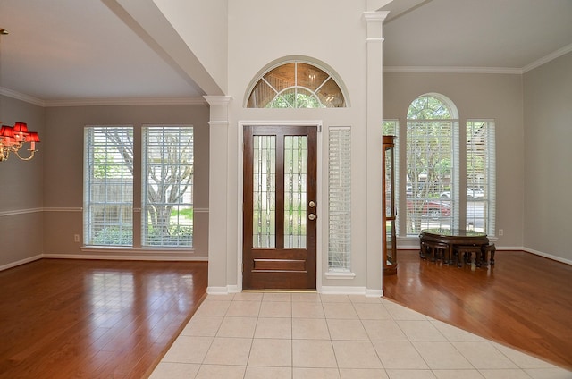 foyer with ornate columns, crown molding, and light hardwood / wood-style flooring