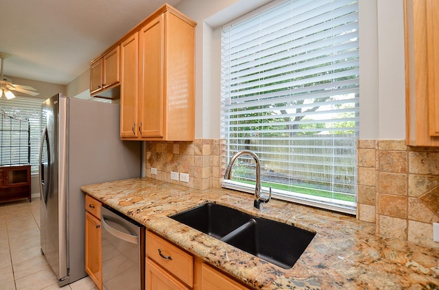 kitchen with plenty of natural light, light tile patterned flooring, sink, and stainless steel appliances