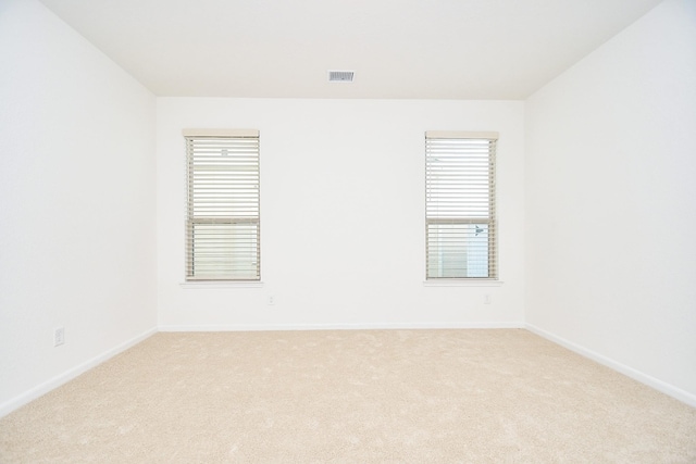 unfurnished room featuring light carpet, baseboards, and visible vents