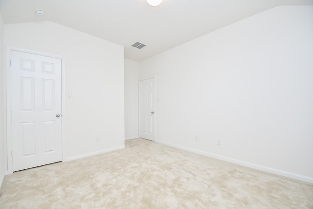 unfurnished room featuring light carpet, visible vents, and lofted ceiling