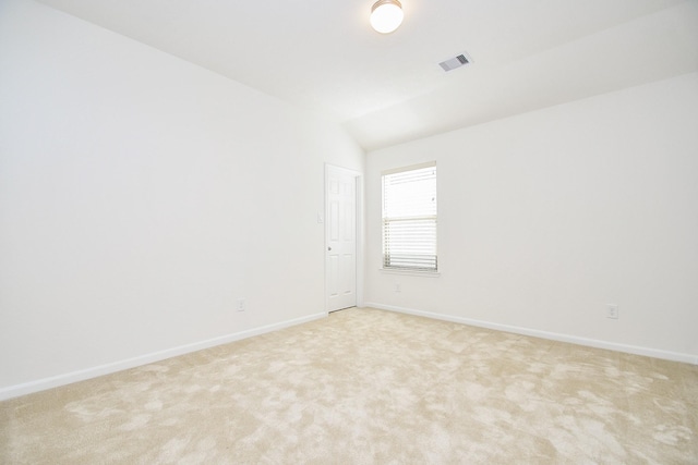 carpeted spare room featuring lofted ceiling