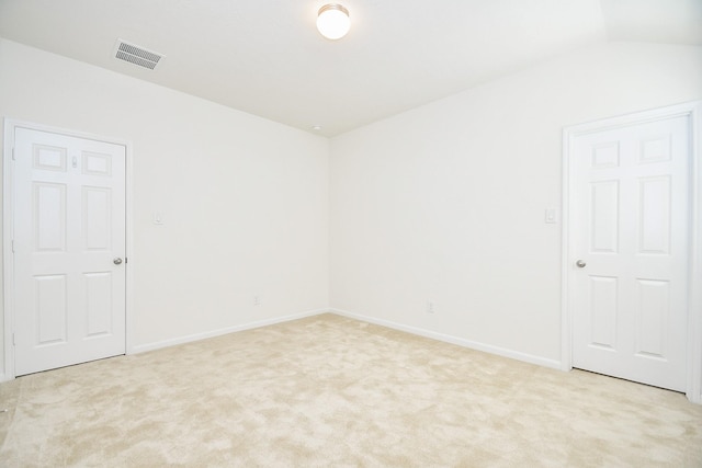 carpeted spare room featuring lofted ceiling