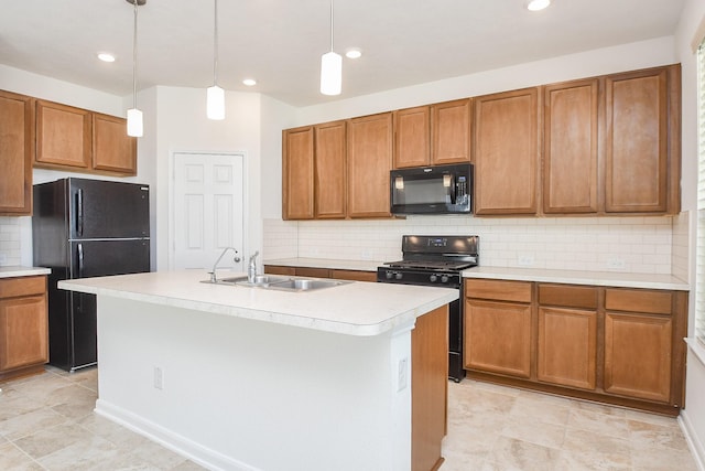 kitchen with sink, an island with sink, hanging light fixtures, and black appliances