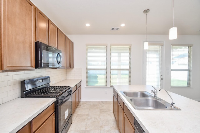 kitchen with tasteful backsplash, sink, black appliances, and decorative light fixtures