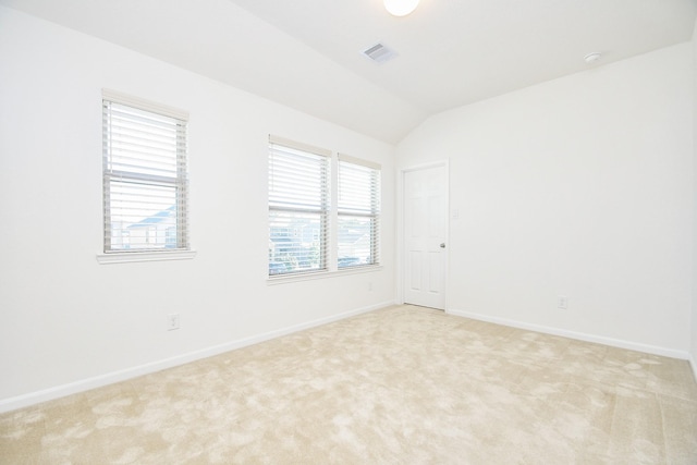 empty room with light colored carpet and lofted ceiling