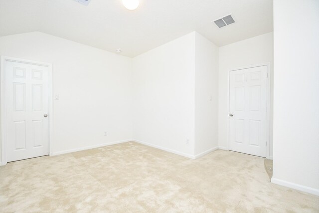 unfurnished room featuring light colored carpet and lofted ceiling