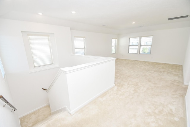 interior space featuring recessed lighting, visible vents, light carpet, and an upstairs landing