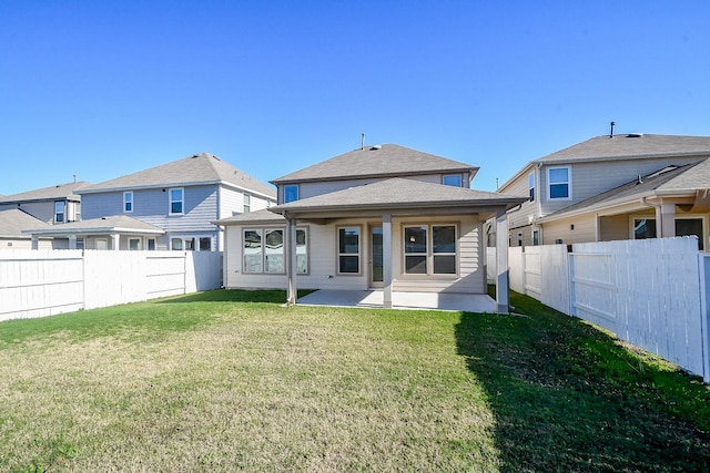 rear view of house featuring a lawn and a patio