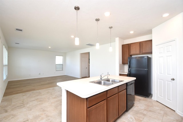 kitchen with decorative backsplash, sink, black appliances, decorative light fixtures, and a center island with sink