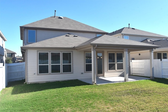 back of house with a fenced backyard, a lawn, and a patio