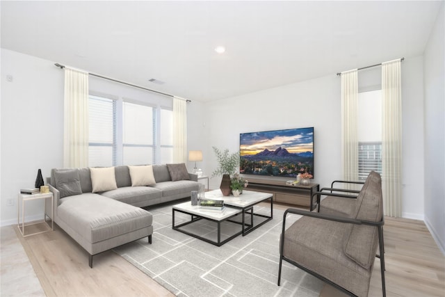 living room featuring baseboards, visible vents, and wood finished floors