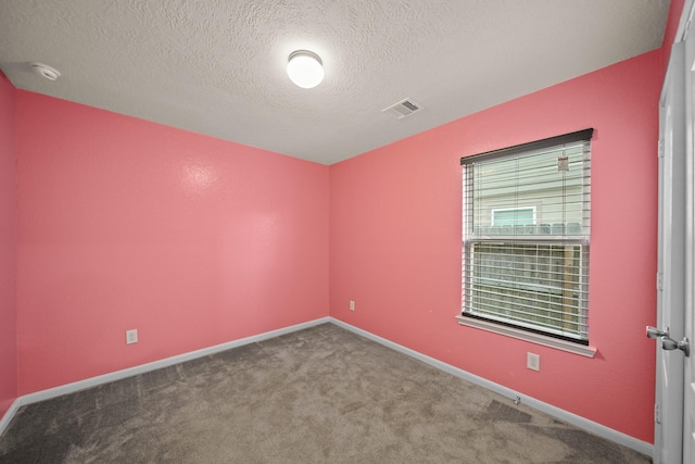 carpeted spare room with a textured ceiling