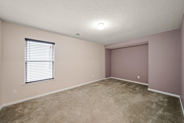 unfurnished room with dark carpet and a textured ceiling