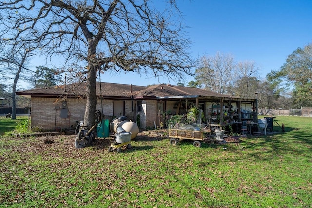 rear view of house featuring a yard