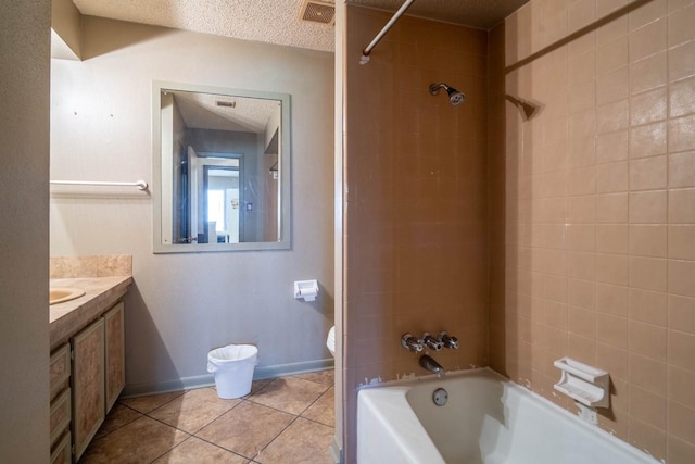 full bathroom featuring vanity, tile patterned flooring, tiled shower / bath combo, toilet, and a textured ceiling