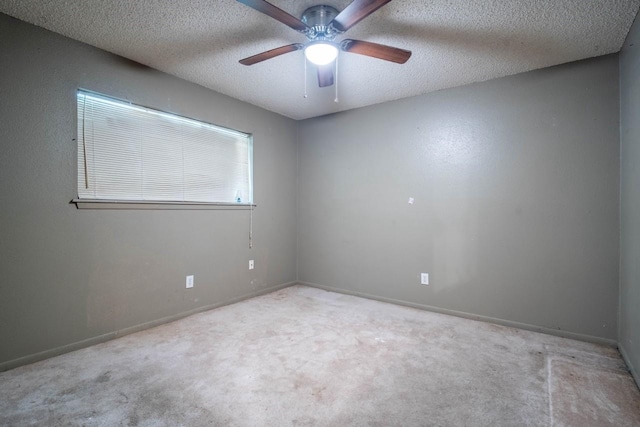 unfurnished room featuring ceiling fan, light colored carpet, and a textured ceiling