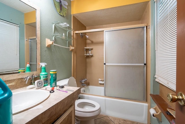 full bathroom with tile patterned floors, vanity, a textured ceiling, shower / bath combination with glass door, and toilet