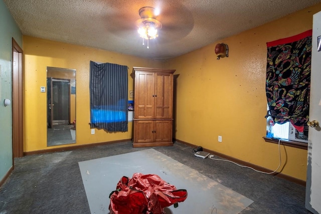 carpeted spare room with ceiling fan and a textured ceiling