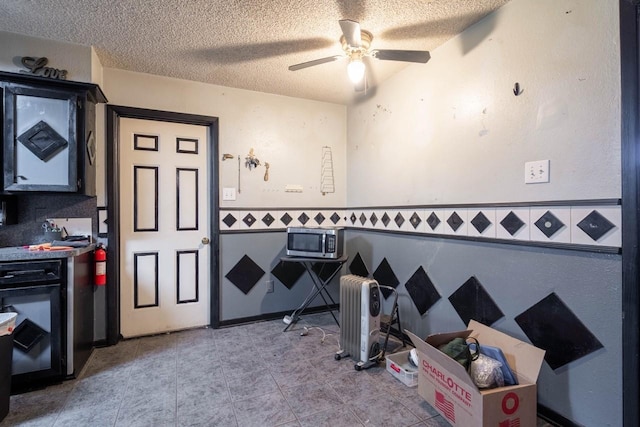 misc room featuring a textured ceiling, ceiling fan, and tile walls