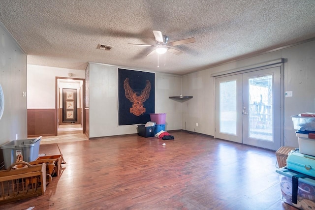 interior space with french doors, light wood-type flooring, a textured ceiling, and ceiling fan