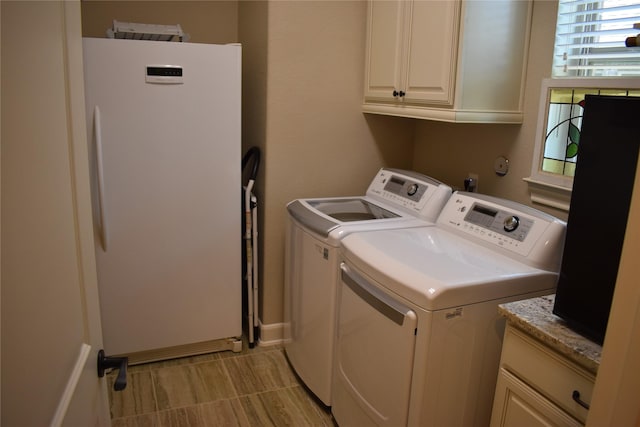 laundry room featuring cabinets and washer and clothes dryer