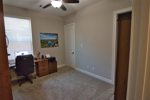 unfurnished office with ceiling fan and light colored carpet