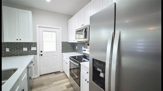 kitchen with decorative backsplash, white cabinetry, and appliances with stainless steel finishes