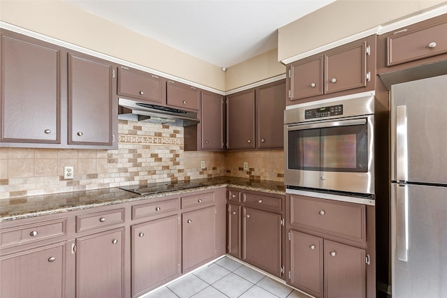 kitchen featuring decorative backsplash, light stone countertops, dark brown cabinets, stainless steel appliances, and light tile patterned floors