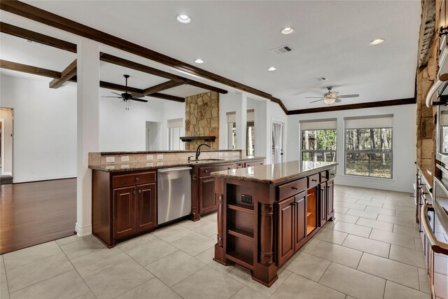 kitchen with light stone countertops, dishwasher, a center island, sink, and beamed ceiling