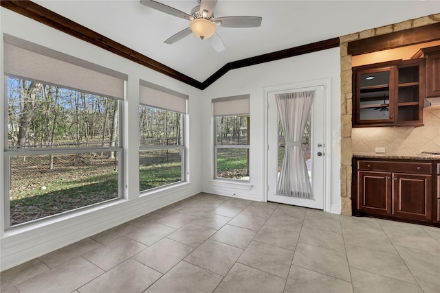 unfurnished dining area with ceiling fan, lofted ceiling, and light tile patterned floors