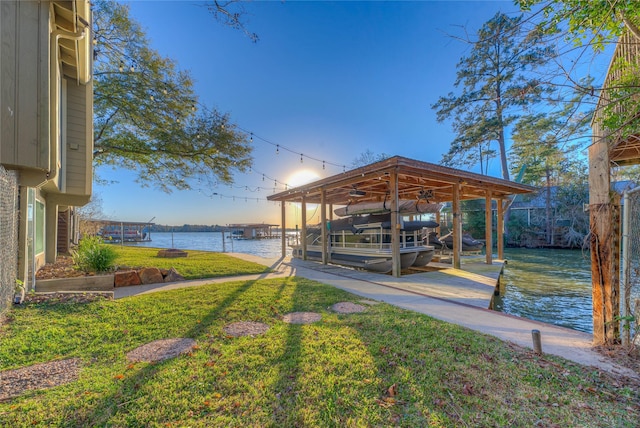 view of dock featuring a lawn and a water view