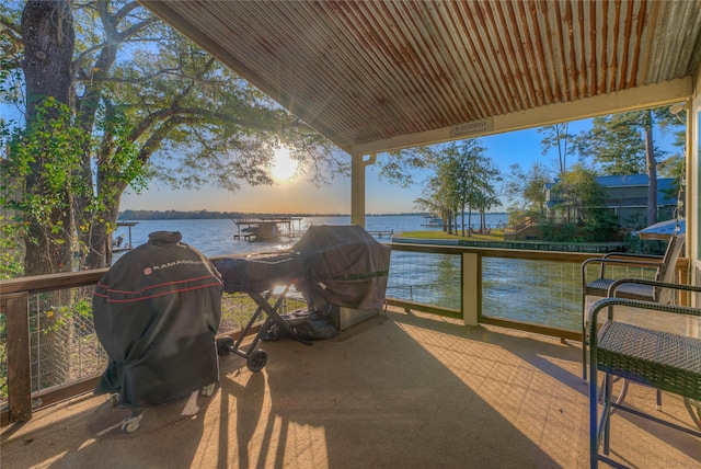 patio terrace at dusk with area for grilling and a water view