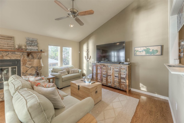 living room with a fireplace, high vaulted ceiling, light hardwood / wood-style flooring, and ceiling fan