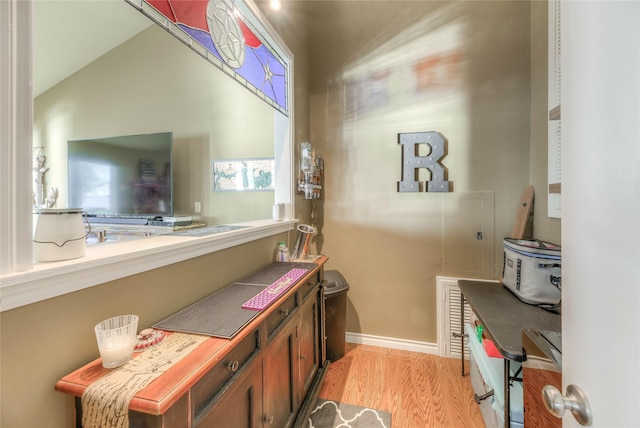 bathroom featuring wood-type flooring and vaulted ceiling