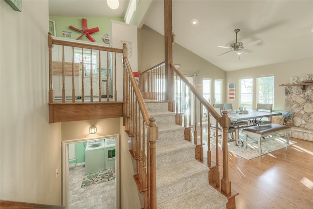 staircase with hardwood / wood-style flooring, ceiling fan, and high vaulted ceiling