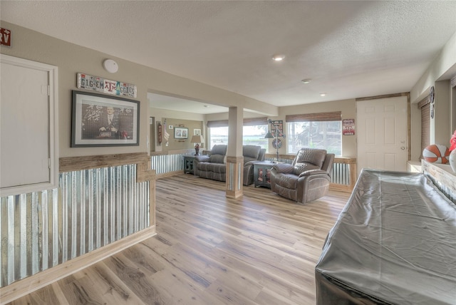 interior space with a textured ceiling and light hardwood / wood-style flooring