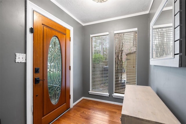 entryway featuring crown molding, a textured ceiling, and wood-type flooring