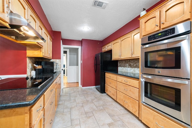 kitchen featuring a textured ceiling, black appliances, tasteful backsplash, and dark stone counters