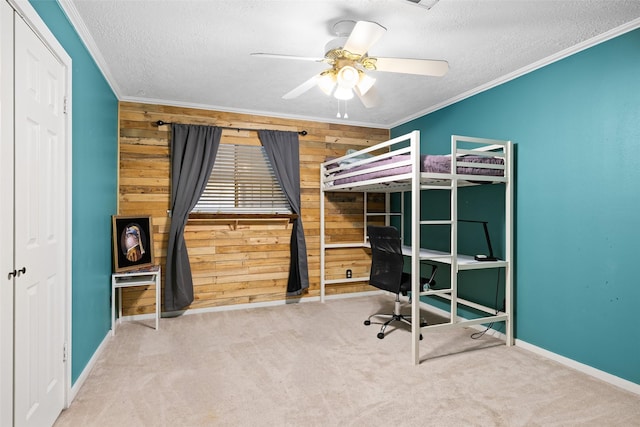 unfurnished bedroom featuring ceiling fan, wood walls, crown molding, and a textured ceiling