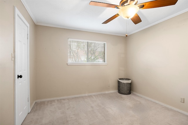 spare room with ceiling fan, light colored carpet, and crown molding