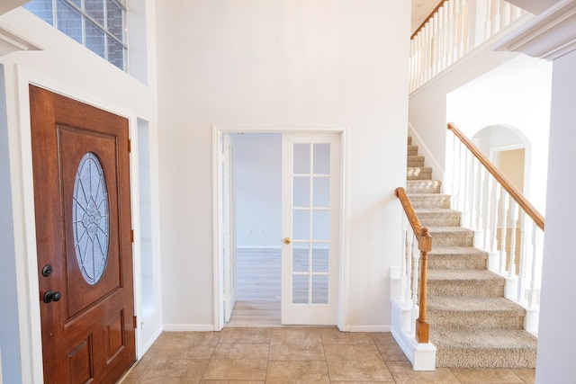 tiled entrance foyer featuring a high ceiling