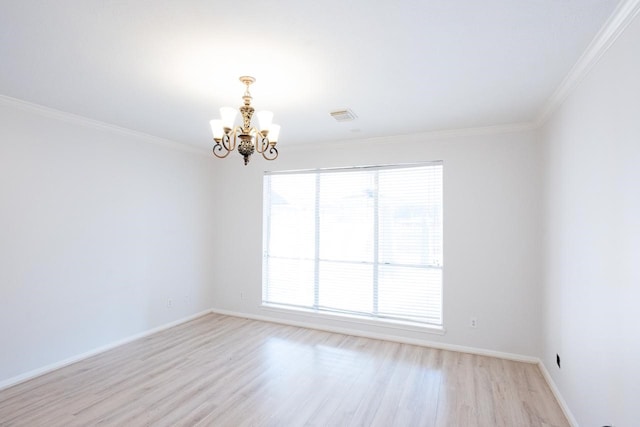 empty room featuring a wealth of natural light, light hardwood / wood-style flooring, ornamental molding, and an inviting chandelier