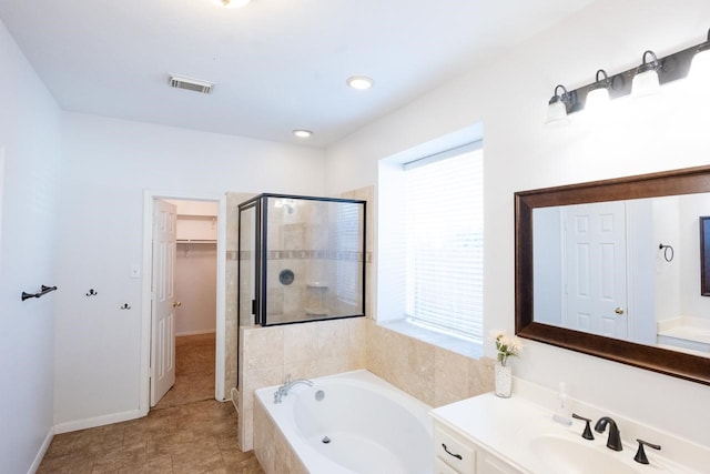 bathroom featuring vanity, plus walk in shower, and a wealth of natural light