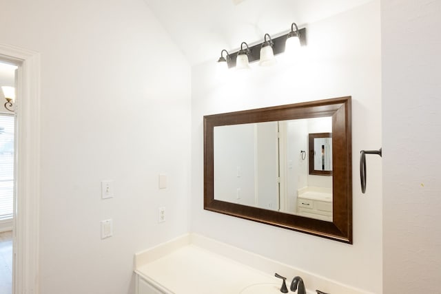 bathroom with vanity and lofted ceiling