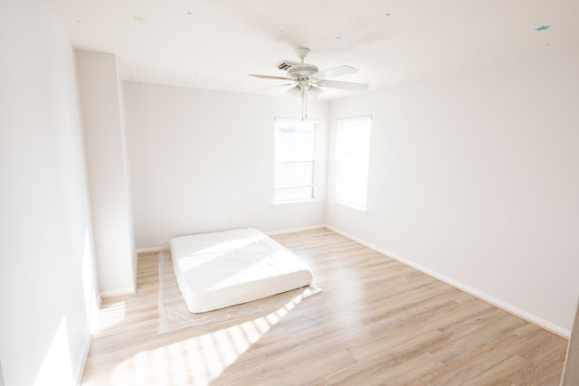 unfurnished bedroom with ceiling fan and light hardwood / wood-style flooring