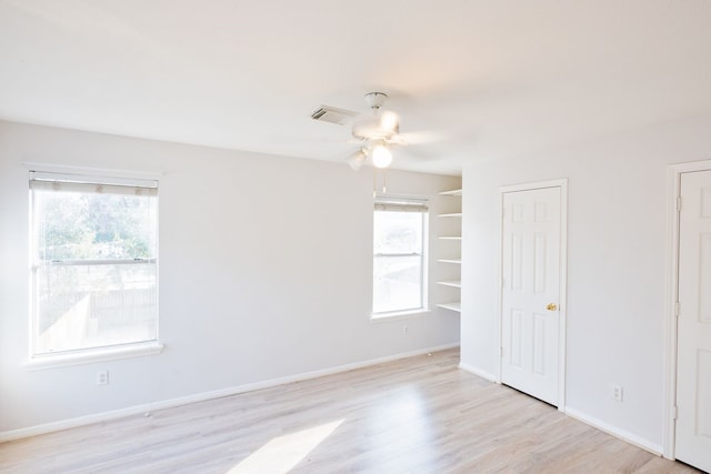 empty room with ceiling fan and light wood-type flooring