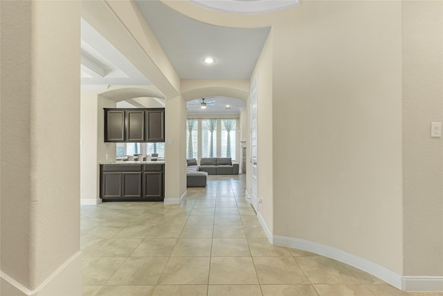 corridor featuring light tile patterned floors and crown molding