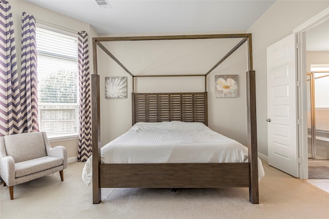 carpeted bedroom featuring ensuite bath