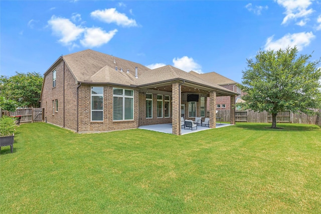 rear view of house featuring a yard, a patio, and ceiling fan